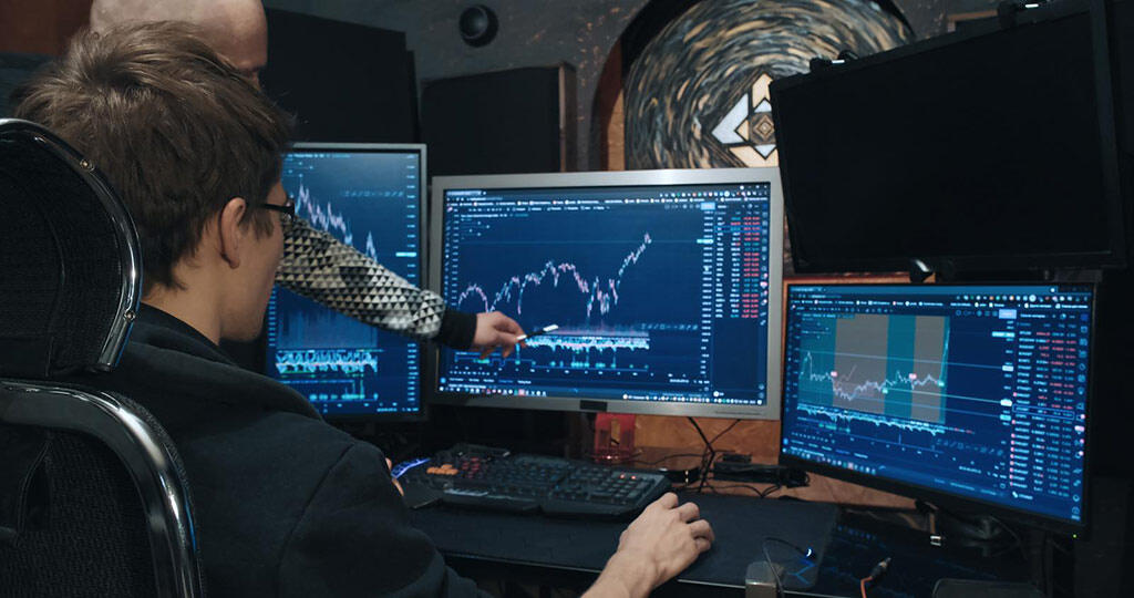 Traders exploring falling and rising quotes at a stock exchange using a professional stock chart Traders exploring falling and rising quotes at a stock exchange using a professional stock chart